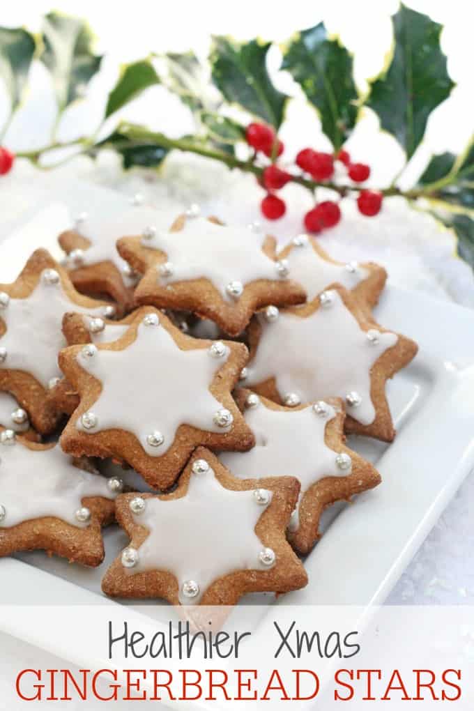 Gingerbread Star Cookies on a white plate with holly in the background.