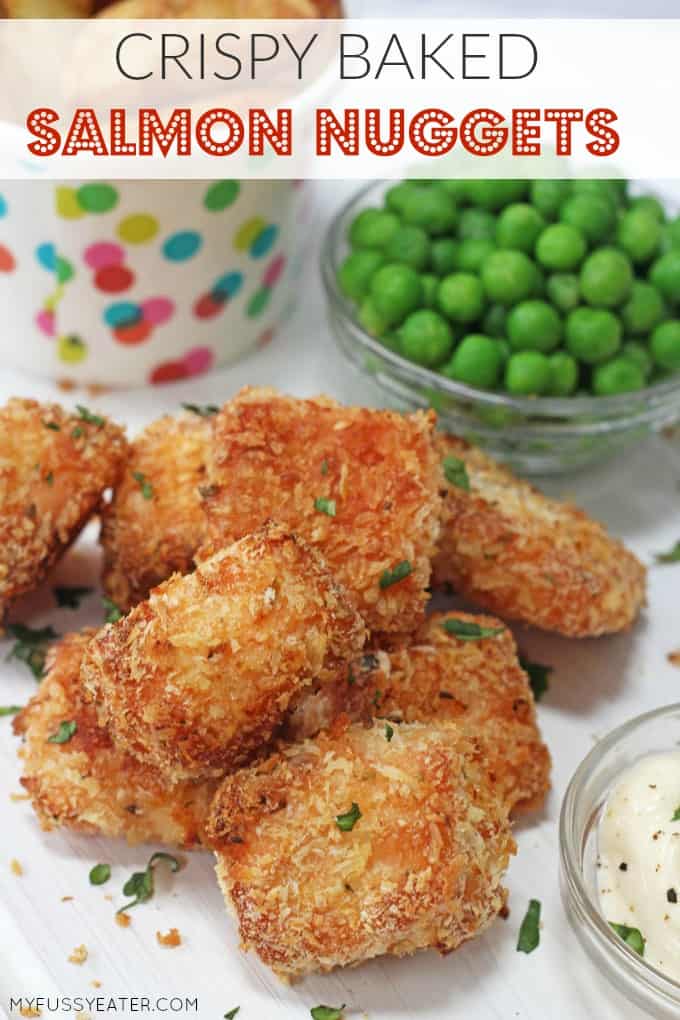 Delicious crispy baked salmon nuggets served with a small glass bowl of garden peas.