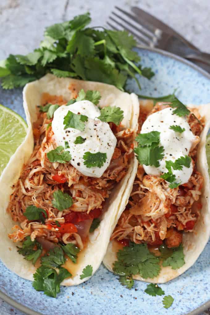 Slow cooker chicken fajitas served with a dollop of sour cream and a sprinkle of coriander.