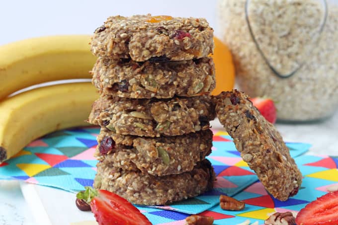 Easy Make-Ahead Breakfast Recipes & Ideas For Kids - Fruit and Nut Breakfast Cookies stacked in a pile with a jar of oats and a bunch of bananas in the background