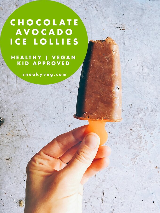 a hand holding a chocolate avocado ice lolly on an orange popsicle holder.