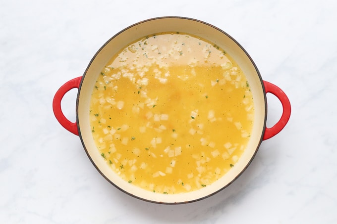 white wine and hot vegetable stock added to the oven proof dish
