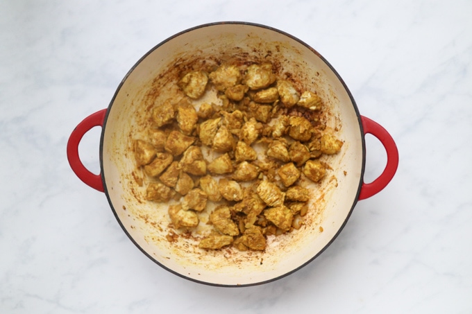 the diced chicken added to the pan with the spices and chopped onion and garlic.