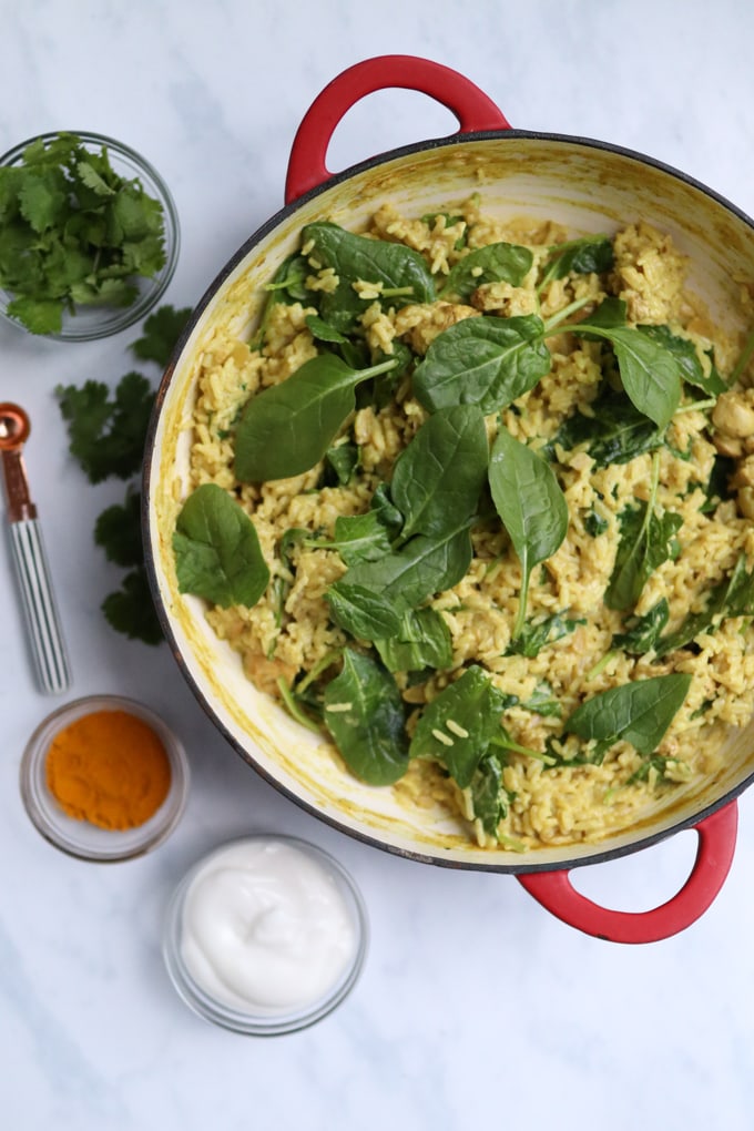 the cooked One Pan Chicken Curry & Rice with spinach leaves added to the top of the dish.