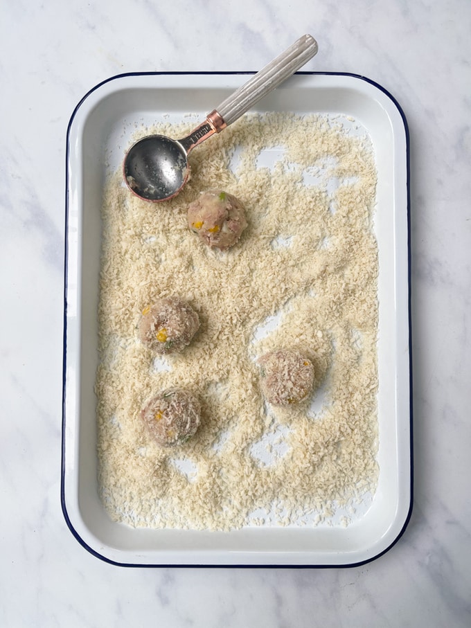 the tuna sweetcorn bite mixture in balls and rolled in panko breadcrumbs on a baking tray