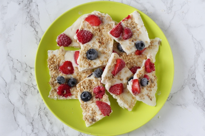Easy Make-Ahead Breakfast Recipes & Ideas For Kids - Breakfast Frozen Yogurt Bark broken into pieces and served on a green plate