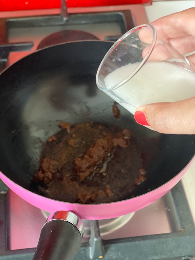Curry paste and cornflour being added to the pan.
