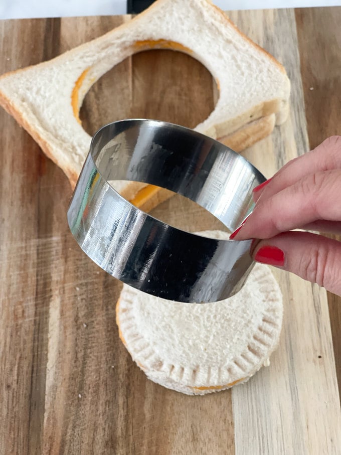 A round pastry cutter is used to shape sandwich.