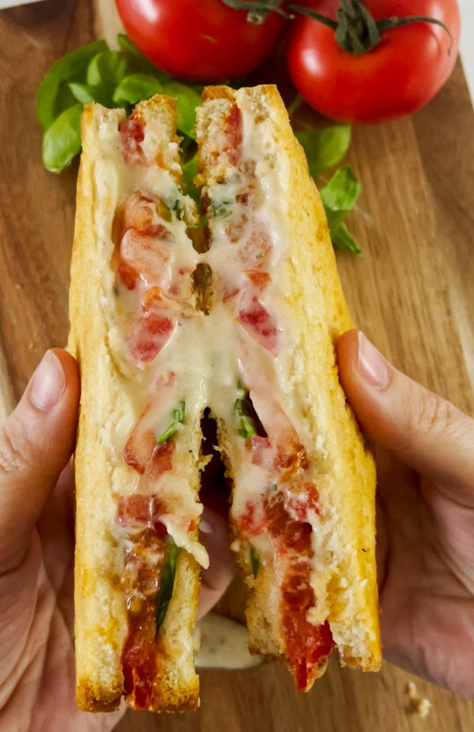 Close up of cooked toastie, showing the inside cheese oozing out.