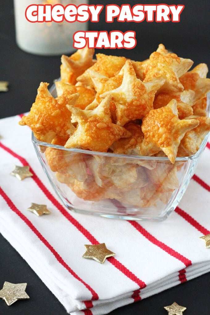 Cheesy Pastry Stars served in a rectangular glass dish on a red and white tea towel with gold stars scattered around.