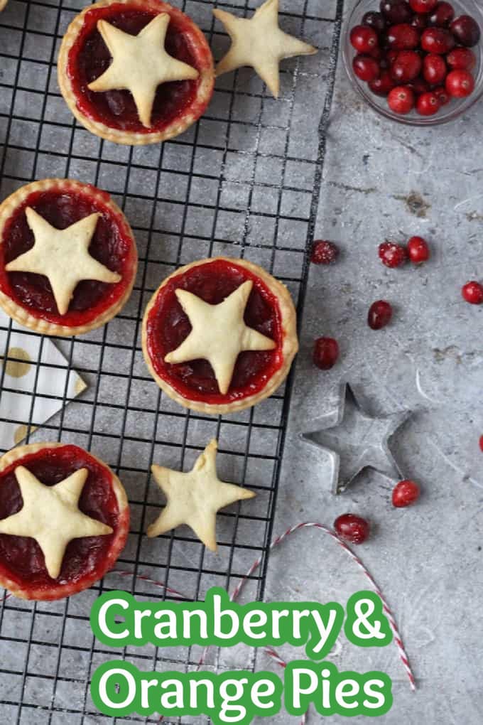 Cranberry and Orange Pies on a wire rack with a bowl of fresh cranberries on the side.