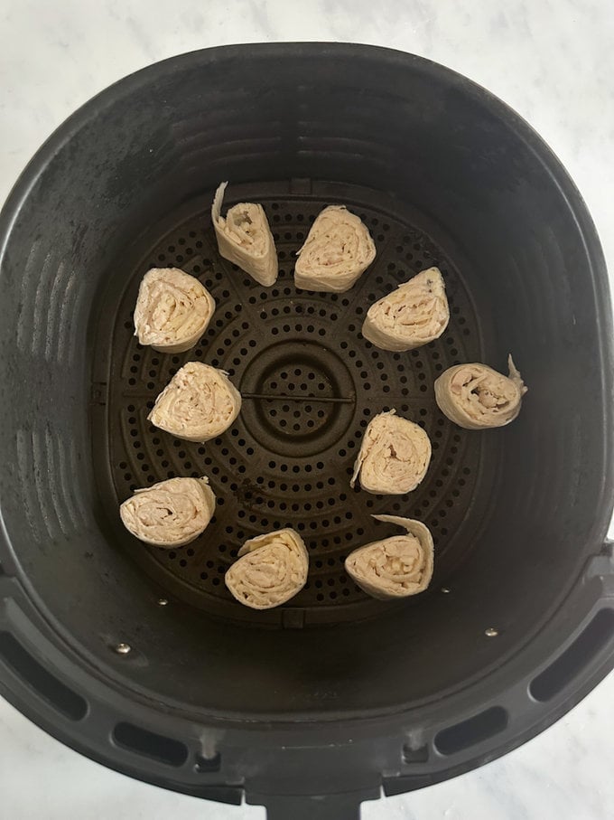 Pinwheels added to the airfryer ready for cooking.