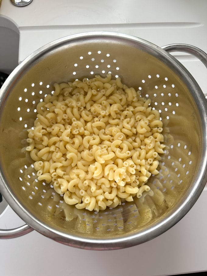Pasta draining in a colander.