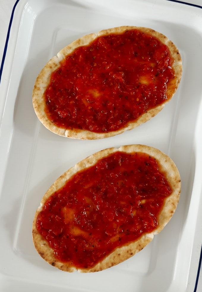 Pitta breads with sauce added.