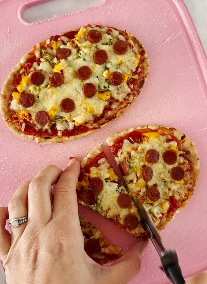 Pitta bread being sliced into triangle pieces.