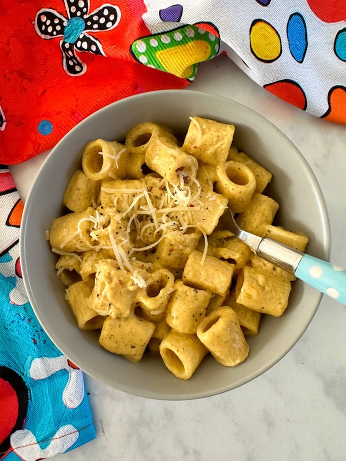 Airfryer Creamy Hidden Veg Pasta Sauce mixed with pasta and served in a light bowl bowl with a blue polka dot fork in it.