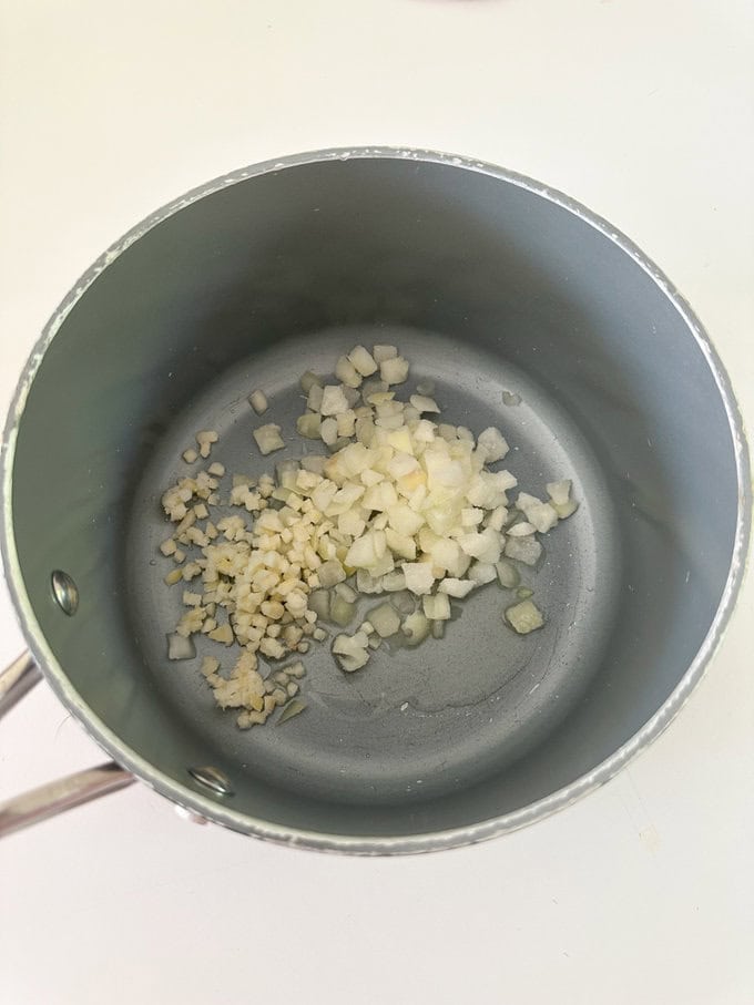Chopped onions and garlic frying in a saucepan.