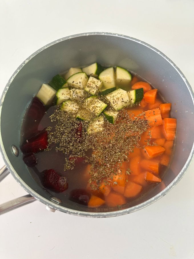 Chopped ingredients added to a saucepan.