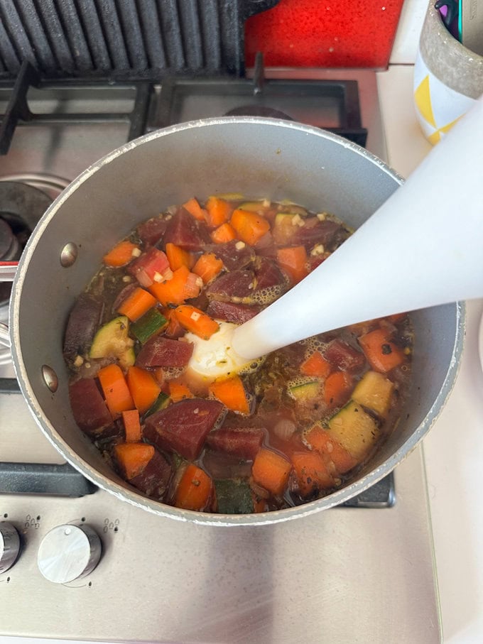 Ingredients being blended together with a hand held blender.