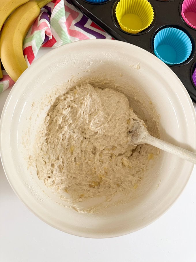 Ingredients for the muffins being added to a large mixing bowl.