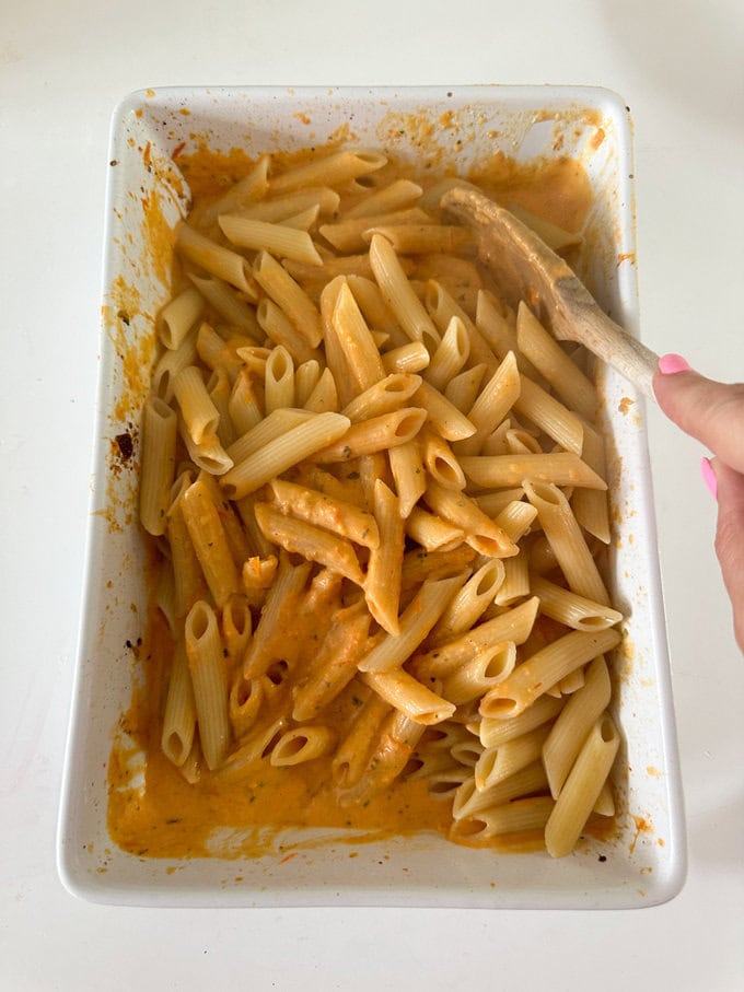 Cooked pasta being added to the sauce.