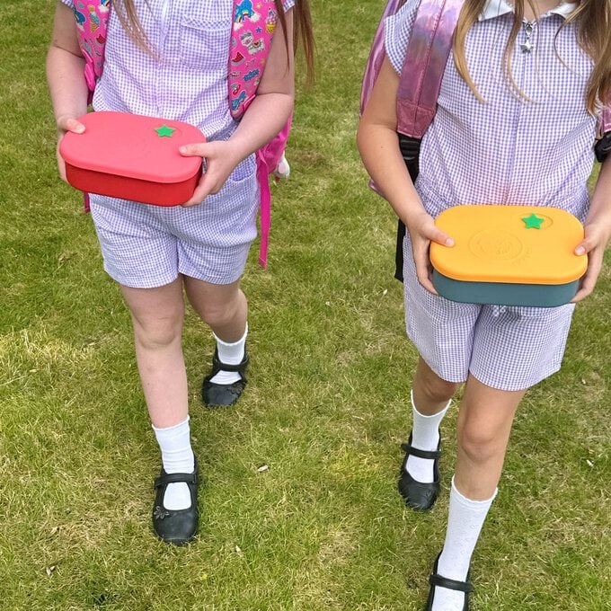 two female children carrying easy open silicone lunchboxes from Pick Plates.