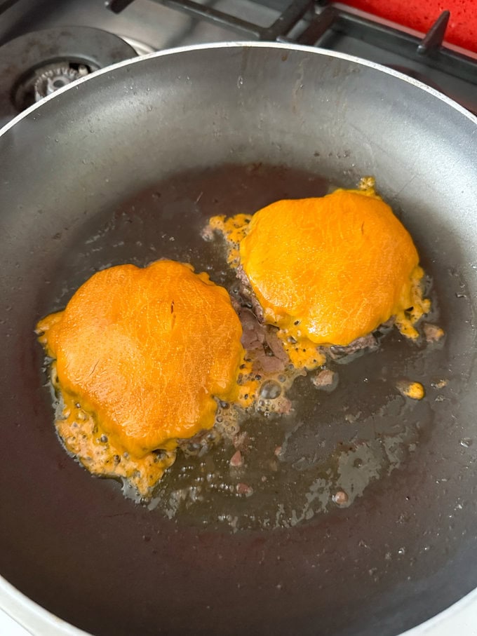Cheese has melted on top of the burgers.