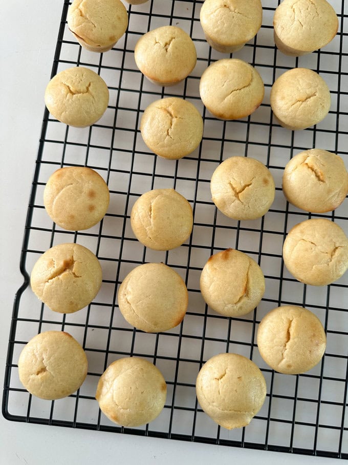 Mini lemon muffins on a wire cooling rack.