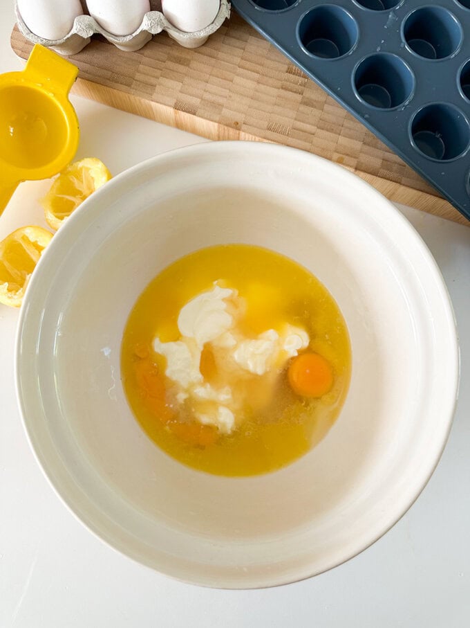 Ingredients being added to a large white mixing bowl.