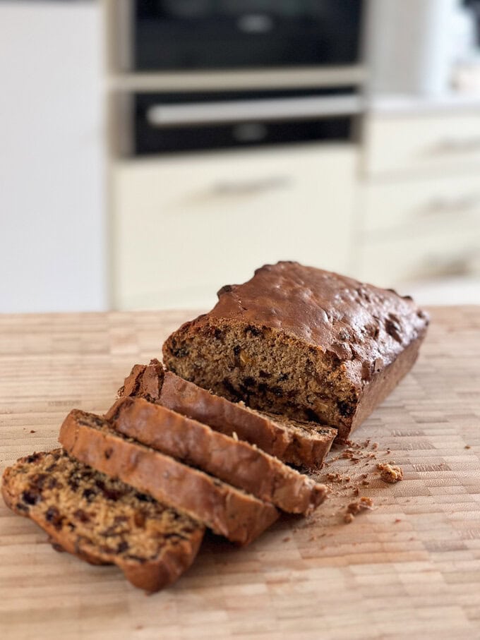 Sliced Irish Barmbrack displayed on a wooden chopping board.