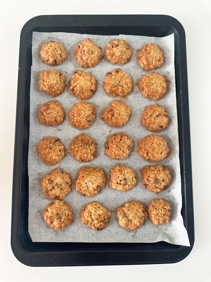 Mini cookies arranged on a baking tray, fresh out of the oven.