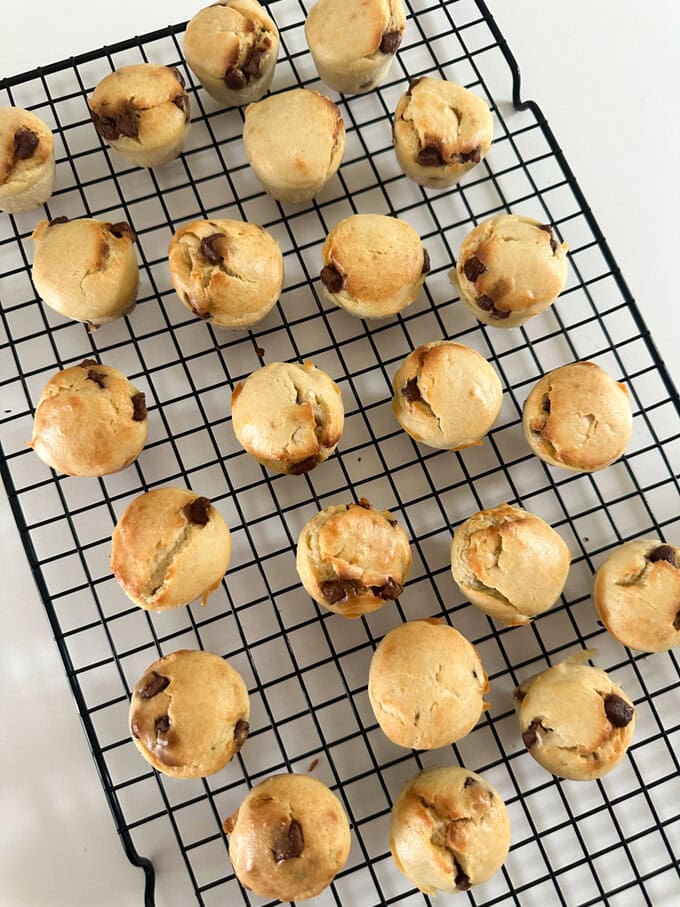Mini chocolate chip muffins on a wire cooling rack.