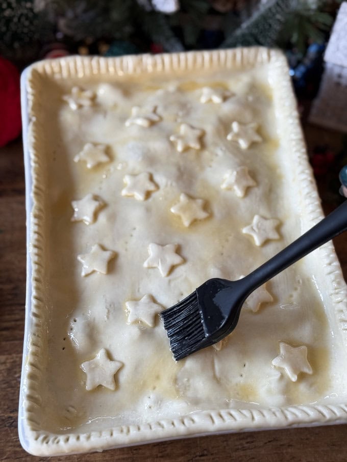Leftover Christmas pie being egg washed ready for the oven.
