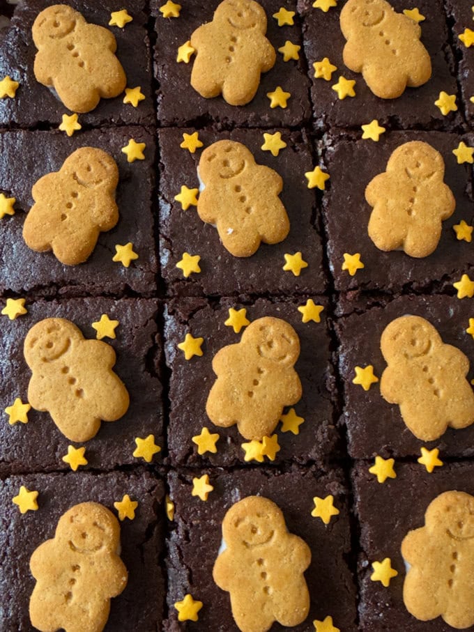 Gingerbread Brownies divided into equal pieces and decorated with mini gingerbread men and little gold star sprinkles.