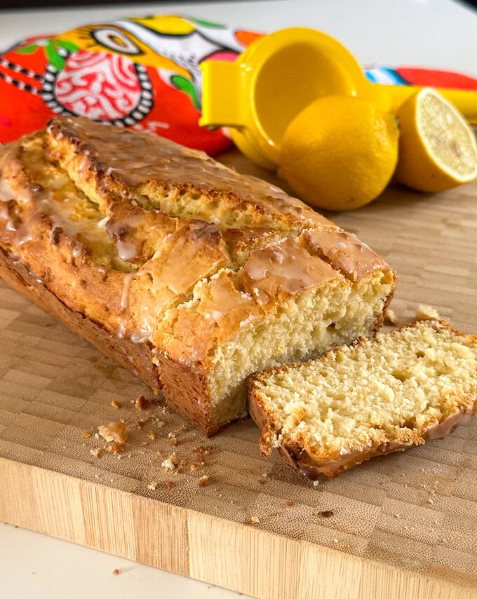lemon loaf fresh out of the oven and served on a wooden chopping board.