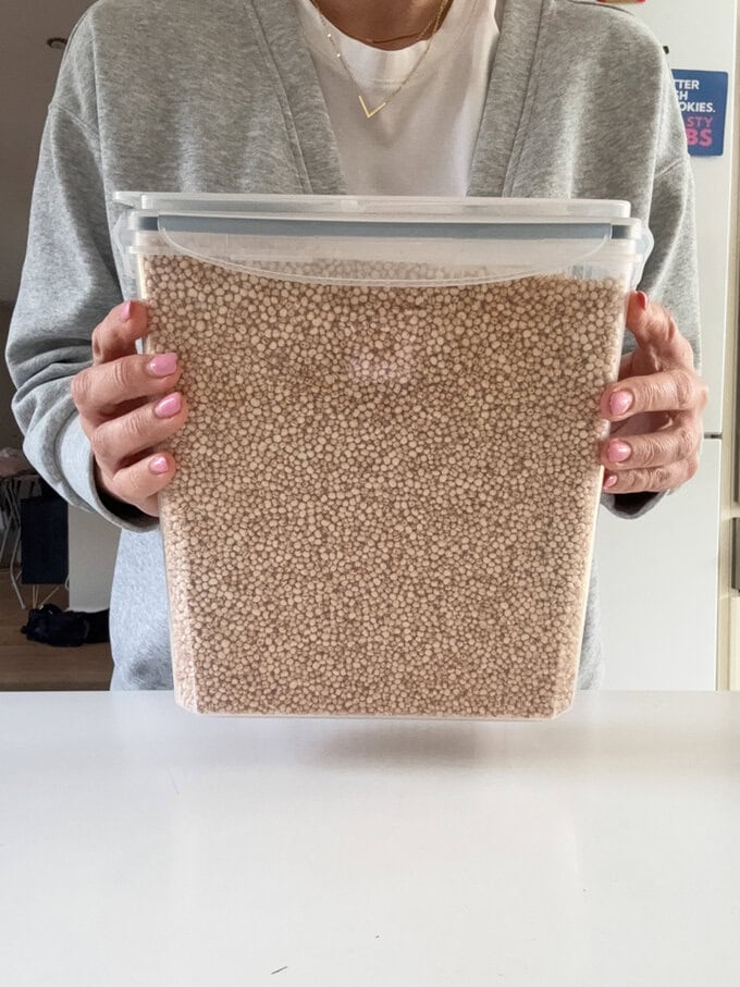 Ciara holding a tub full of Quinoa.