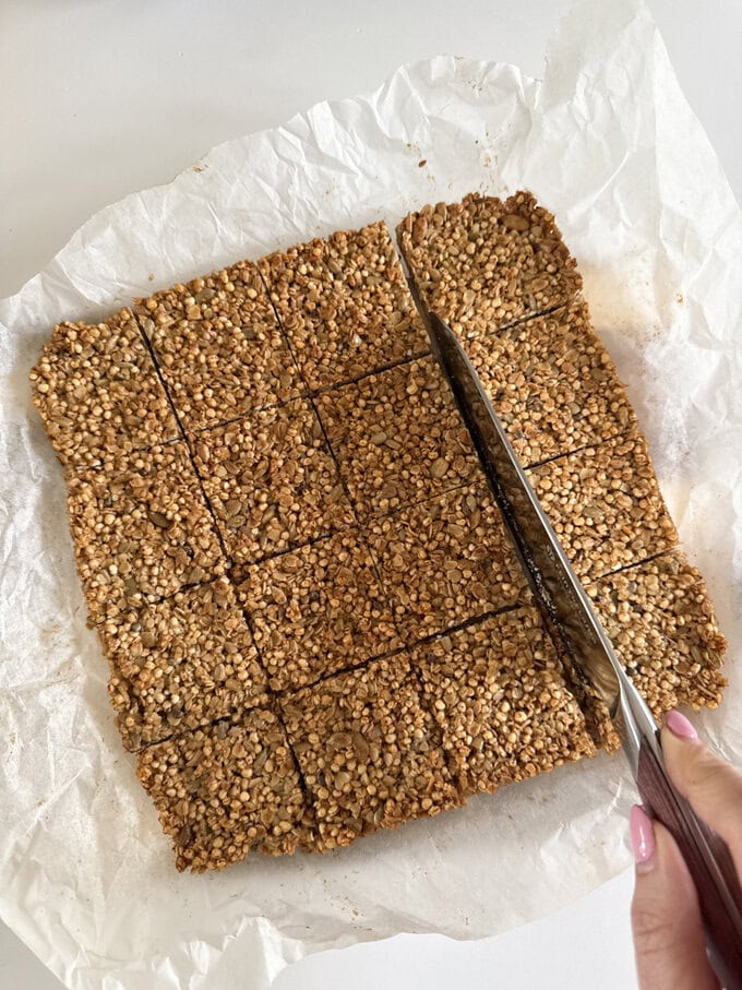 Quinoa flapjacks fresh out of the oven and being cut into equal squares ready to be served.
