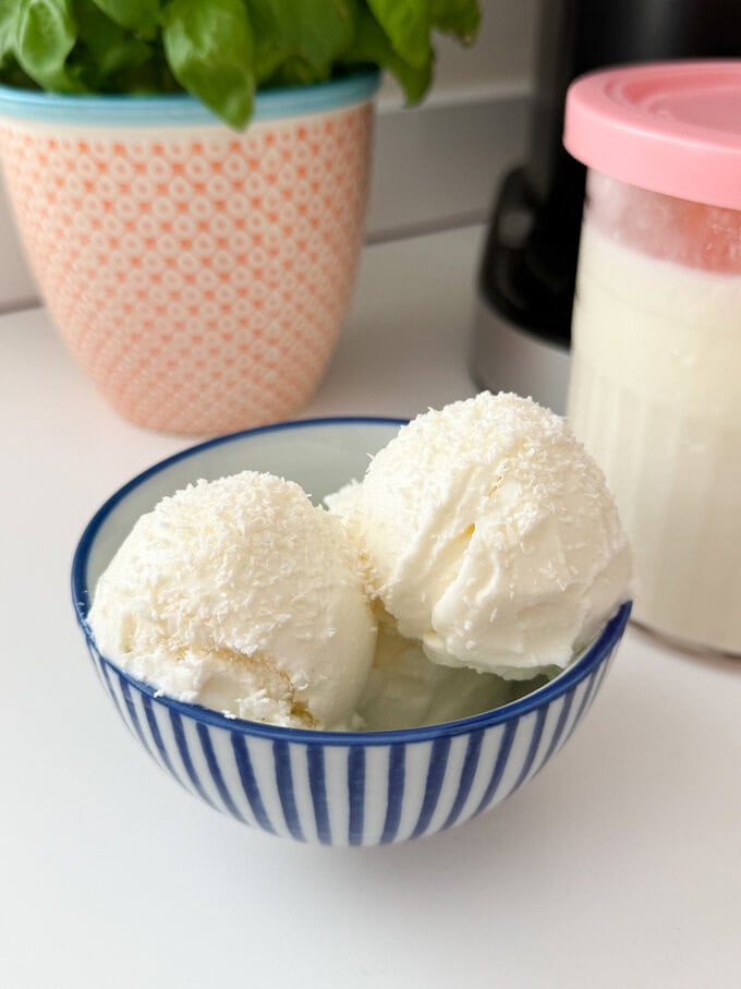 Two scoops of Ninja Creami Coconut Frozen Yogurt in a blue and white striped ice cream bowl.