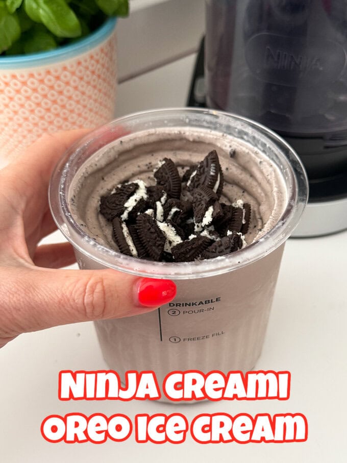 Oreo Ice Cream in a Ninja Creami pot topped with crushed Oreo biscuit pieces.