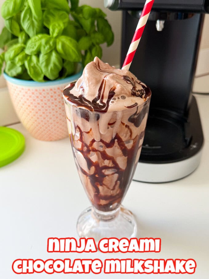 A chocolate milkshake in an old fashioned tall milkshake glass with a red and white striped straw in it.