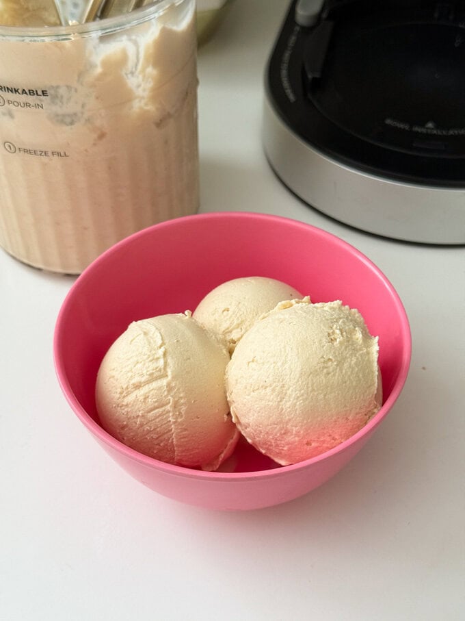 Frozen yogurt made in the Ninja Creami with peanut butter and banana, served in a bright pink ice cream bowl.