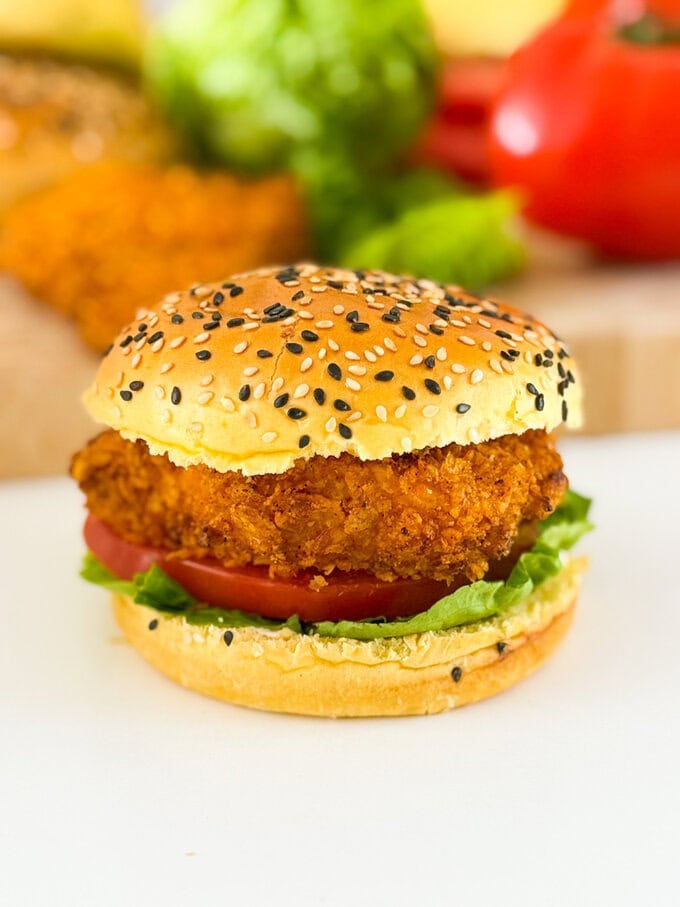 The most delicious homemade crispy chicken burgers. Made with a cornflake coating for extra crunch and oven baked to keep them super healthy. Served in a seeded burger bun with fresh slices of tomato and lettuce leaves.