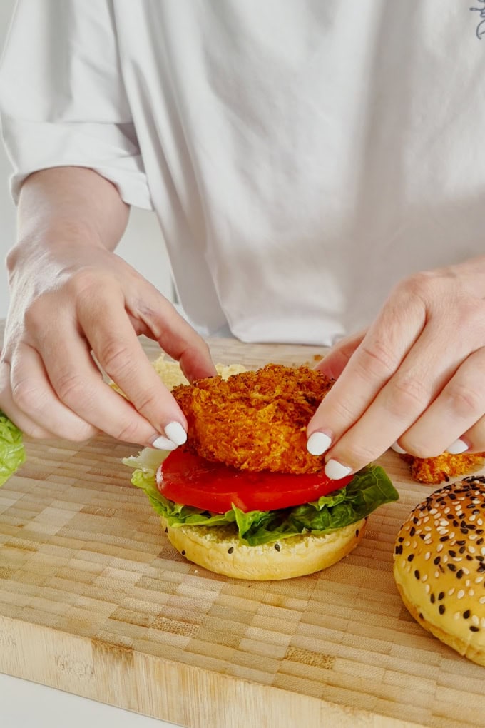The most delicious homemade crispy chicken burgers. Made with a cornflake coating for extra crunch and oven baked to keep them super healthy. Served in a seeded burger bun with fresh slices of tomato and lettuce leaves.