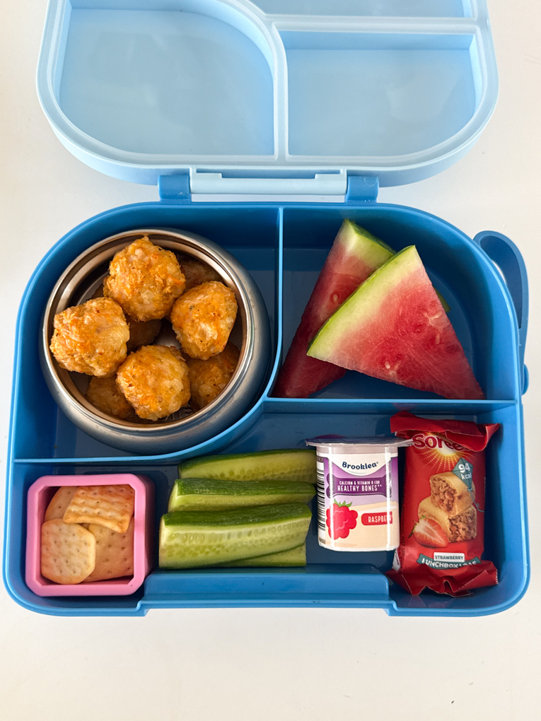 Chicken Sausage Bites served in a thermos lunchbox along with fresh fruit and veggies.
