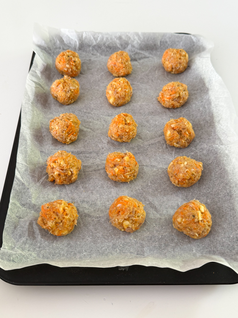 Chicken Sausage bites arranged on a baking tray ready for the oven.