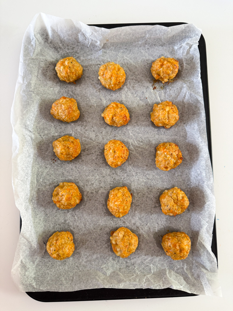 Chicken Sausage bites arranged on a baking tray ready for the oven.